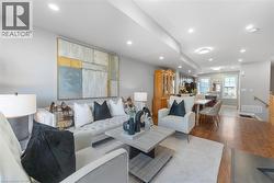 Open-concept living space featuring recessed lighting, wood-finish flooring, and light gray wall paint - 