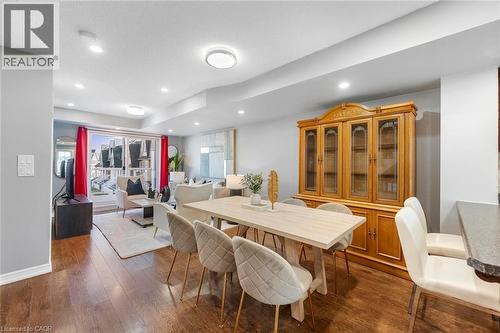 Open-concept living and dining area featuring wood-finish flooring, recessed lighting, and a sliding glass door leading to a balcony - 1380 Costigan Road Unit# 13, Milton, ON 