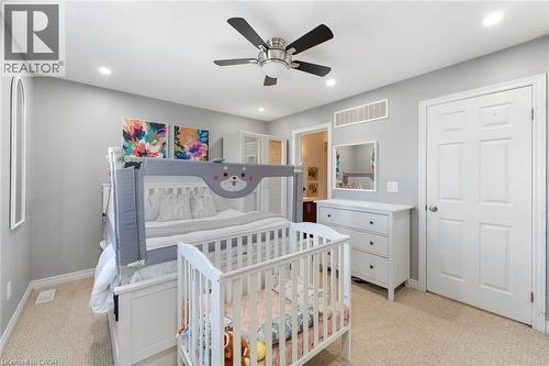 Carpeted bedroom featuring a ceiling fan with integrated lighting, recessed lighting, and a paneled white door - 1380 Costigan Road Unit# 13, Milton, ON 