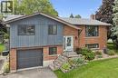 Split-level residence featuring brick and vertical siding, a paved driveway, an attached garage, and mature landscaping - 8 Christian Street, Baden, ON 
