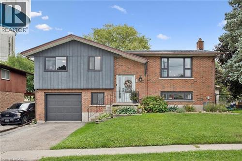 Brick and siding exterior with an attached garage, paved driveway, and mature landscaping - 8 Christian Street, Baden, ON 