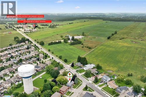 Aerial perspective showcasing a developed residential area, expansive green fields, and a prominent water tower - 8 Christian Street, Baden, ON 