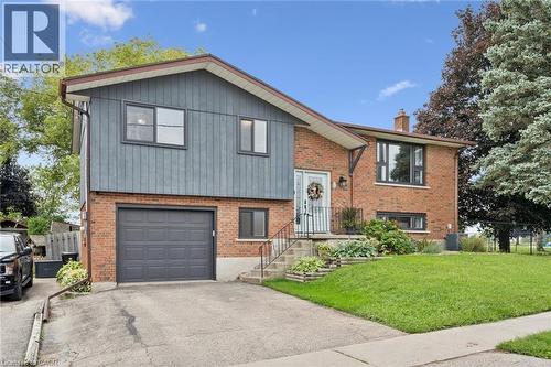 Split-level exterior featuring brick and vertical siding, attached garage, and a concrete driveway - 8 Christian Street, Baden, ON 
