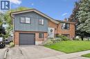 Split-level exterior featuring brick and vertical siding, attached garage, and a concrete driveway - 8 Christian Street, Baden, ON 