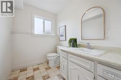 White vanity with integrated sink, chrome faucet, and arched mirror - 