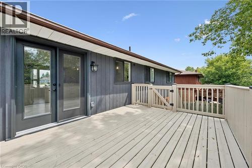Expansive outdoor deck with a light wood-finish surface, complete with a security gate and dark brown gutters - 8 Christian Street, Baden, ON 