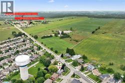 Aerial perspective showcasing a developed residential area, expansive green fields, and a prominent water tower - 