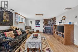 Corner brick gas fireplace with a built-in insert and wood-finish flooring throughout - 