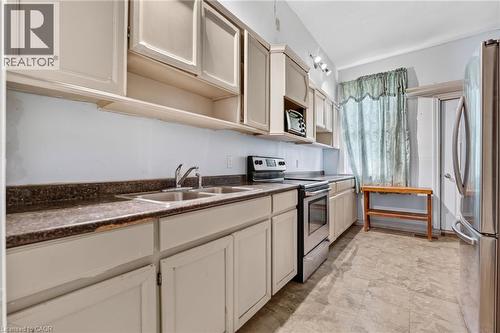 Functional kitchen with upper and lower cabinetry, stainless steel double basin sink, and integrated stainless steel range - 199 N Locke Street N, Hamilton, ON 