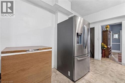 Stainless steel refrigerator with a water and ice dispenser, white crown molding, and neutral-toned floor tile - 199 N Locke Street N, Hamilton, ON 