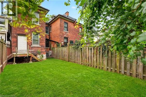 Expansive grassy yard area with wood fencing and brick exterior - 199 N Locke Street N, Hamilton, ON 