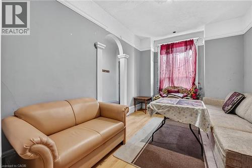 Light-toned wood-finish flooring, light gray wall paint, and white crown molding - 199 N Locke Street N, Hamilton, ON 