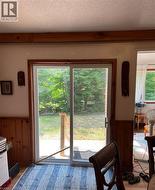Sliding glass door leading to a concrete patio, featuring a wood railing - 