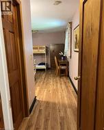 Wood-finish flooring extending from the entry, with paneled doors and light-toned walls - 