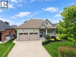 Two-car attached garage, covered front porch, concrete driveway, front yard landscaping, and exterior siding - 