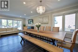 Expansive living area with dark wood-finish flooring, recessed lighting, and crown molding - 