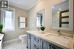Double vanity with undermount sinks, stone-finish countertop, and gray cabinetry - 