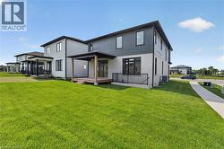 Modern exterior featuring a covered deck, black railings, and a multi-toned facade with vertical and horizontal siding - 