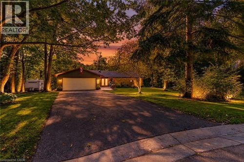 Paved driveway leading to a two-car garage, mature trees, and a well-maintained lawn - 80 Glenda Jane Drive, Campbellville, ON 