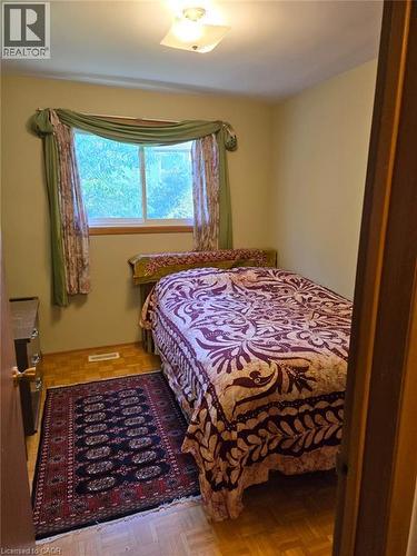 Parquet wood-finish flooring with a window offering natural light, and a ceiling-mounted light fixture - 410 Lakeview Drive, Waterloo, ON 