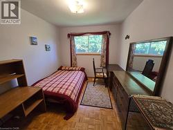 Parquet wood flooring, a window with natural light, and an overhead light fixture - 