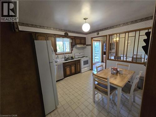 Kitchen featuring wood-finish cabinetry, white appliances, and a tiled floor - 410 Lakeview Drive, Waterloo, ON 