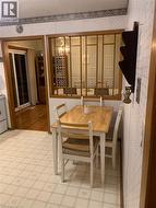 Wood-finish room divider with decorative panels, light-toned patterned wall covering, tile flooring, and a sliding glass door - 