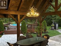 Expansive covered patio with exposed wood beams and a unique chandelier - 