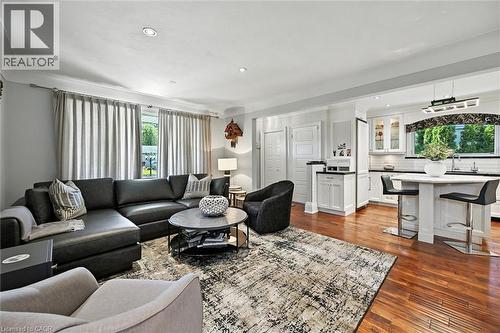 Warm wood-finish flooring, recessed ceiling lighting, and a white kitchen with dark countertops - 2209 Ghent Avenue, Burlington, ON 