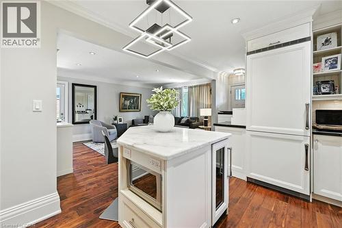 Hardwood flooring, kitchen island with a light-toned countertop, built-in panel-front refrigerator, built-in microwave, and recessed lighting - 2209 Ghent Avenue, Burlington, ON 