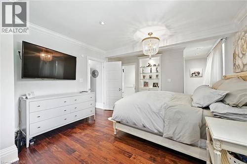 Rich wood-finish flooring, recessed lighting, crown molding, and a built-in display cabinet with glass shelving - 2209 Ghent Avenue, Burlington, ON 