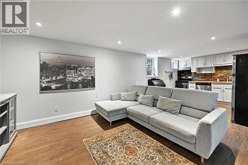 Recessed lighting, wood-finish flooring, white cabinetry, dark stone backsplash, and stainless steel dishwasher - 2209 Ghent Avenue, Burlington, ON 