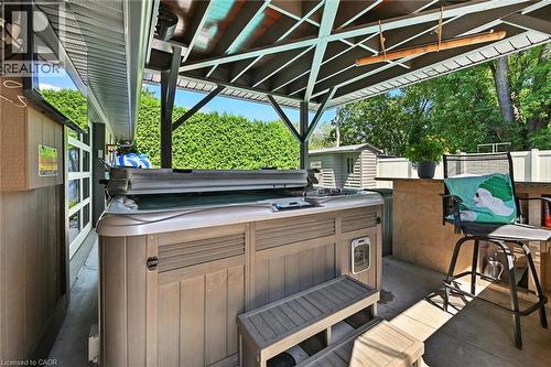 Outdoor spa with built-in steps, covered patio structure, concrete hardscaping, and a privacy fence - 2209 Ghent Avenue, Burlington, ON 