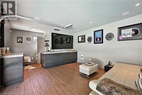 Wood-finish flooring with a built-in media console, recessed lighting, and integrated ceiling speakers - 2209 Ghent Avenue, Burlington, ON 