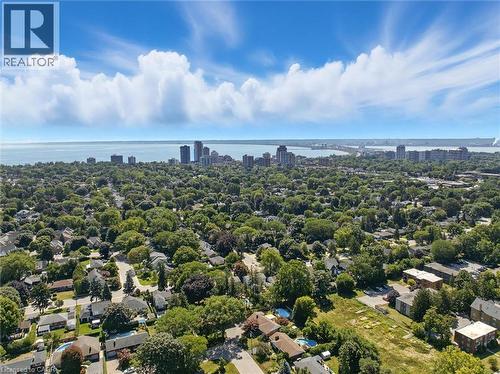 Expansive area featuring mature tree canopies, residential structures, and a distant cityscape along the water - 2209 Ghent Avenue, Burlington, ON 