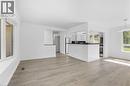 Open concept living area featuring wood-finish flooring, white walls, and a large bay window - 49 Beverly Crescent, Welland, ON 