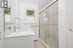 White vanity with integrated sink, modern brushed nickel faucet, and white countertop - 