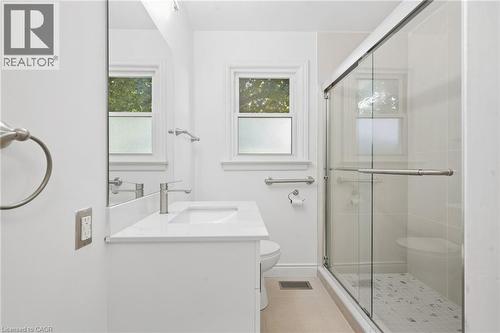 White vanity with an integrated sink, polished chrome faucet, and quartz countertop - 49 Beverly Crescent, Welland, ON 