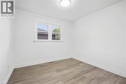 Recessed ceiling light, dual-pane window, wood-finish flooring, and white trim - 
