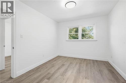 White walls, wood-finish flooring, and a flush-mount ceiling light - 49 Beverly Crescent, Welland, ON 