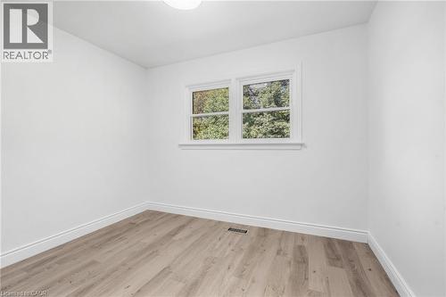 Recessed lighting, wood-finish flooring, white walls, and a window with white trim - 49 Beverly Crescent, Welland, ON 