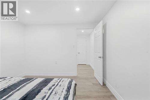 Recessed lighting illuminates neutral white walls and wood-finish flooring - 49 Beverly Crescent, Welland, ON 
