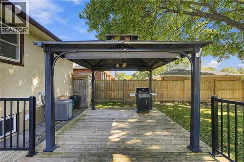 Expansive wood-finish deck with a built-in gazebo featuring a metal frame and covered roof - 49 Beverly Crescent, Welland, ON 