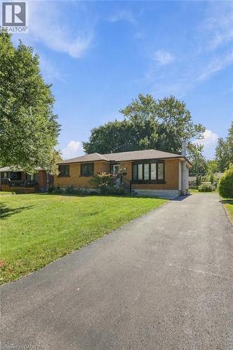 Brick exterior, multiple windows, asphalt driveway, and green lawn - 49 Beverly Crescent, Welland, ON 