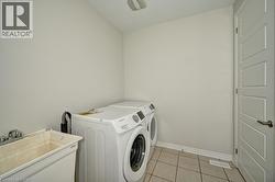 Utility sink with chrome faucet, light tile flooring, and a paneled door - 