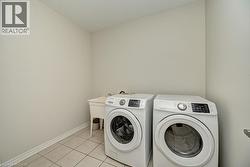 Laundry area with tiled flooring and a utility sink - 