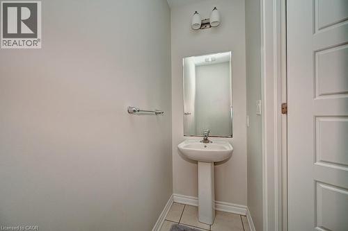 Pedestal sink with chrome faucet, wall-mounted mirror, and overhead vanity lighting - 236 Ridge Road, Cambridge, ON 