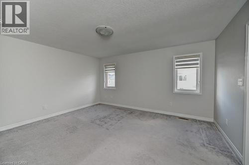 Neutral wall color, two windows with blinds, flush mount ceiling light, and wall-to-wall carpeting - 236 Ridge Road, Cambridge, ON 