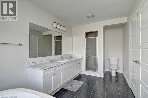 Dual vanity with a white marble-finish countertop, undermount sinks, and white shaker-style cabinetry - 236 Ridge Road, Cambridge, ON 
