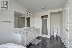 Dual vanity with a white marble-finish countertop, undermount sinks, and white shaker-style cabinetry - 